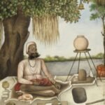 man sitting beside river painting